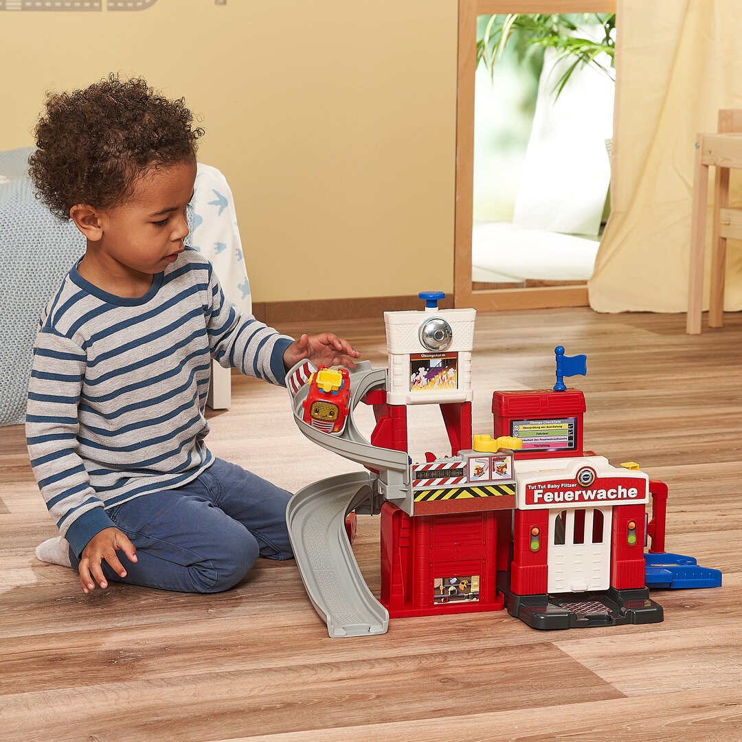 VTech Tut Tut Baby Flitzer Feuerwache, interaktives Spielgebäude ab 1 Jahr VTech Tut Tut Baby Flitzer Feuerwache aus Kunststoff mit 3 Liedern & 6 Melodien, 4 magischen Sensoren, Feuer-Spielstein, Löschschlauch, Hundefigur, kindersicher ab 1 J., Holz, Person